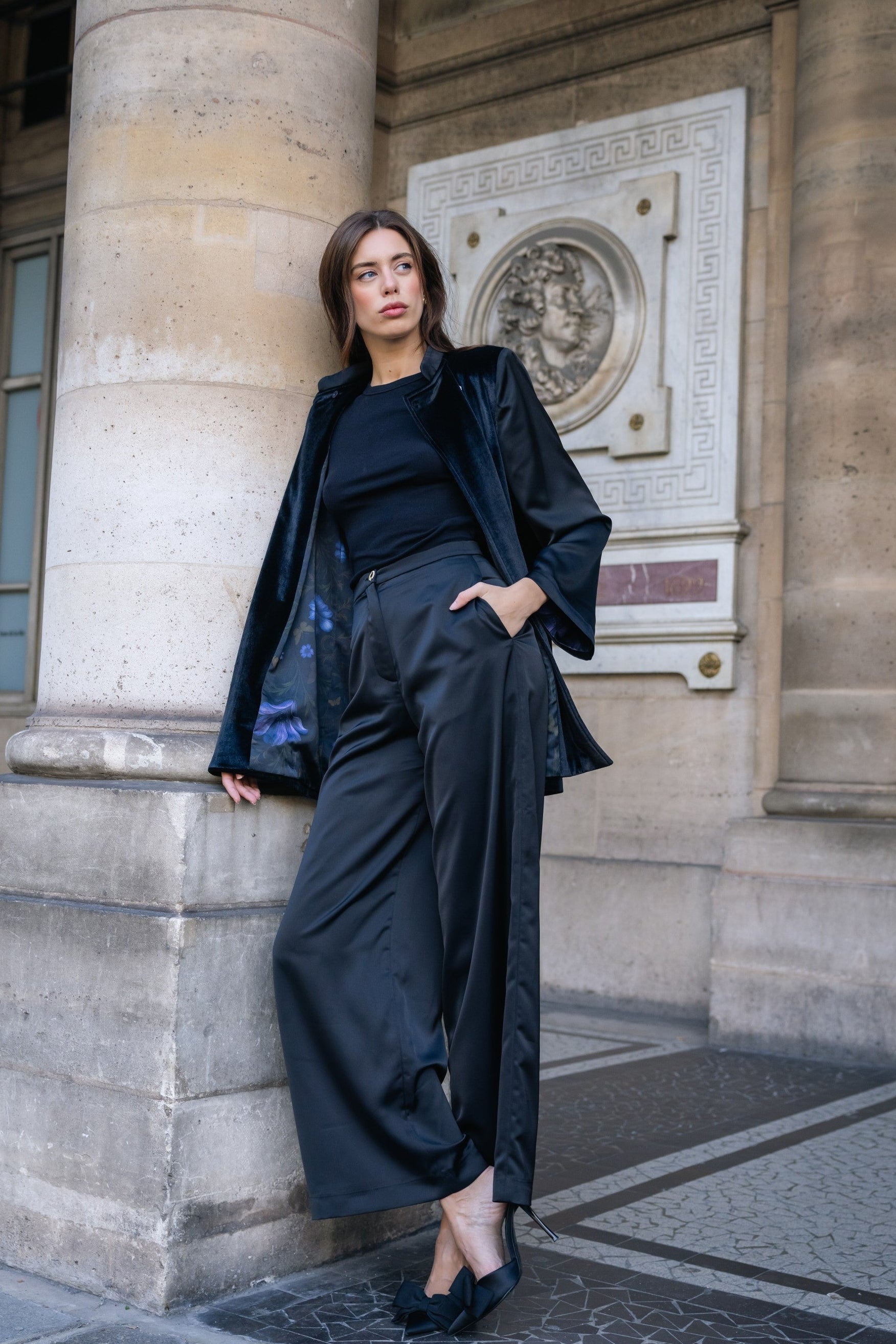Woman in a black velvet suit standing in front of a classical building in Paris. Office outfit. Work outfit. business outfit. Women suit. 