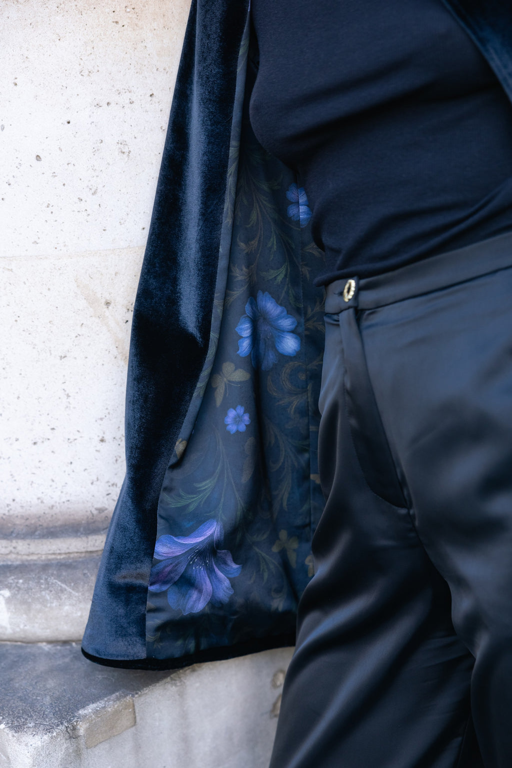 Person wearing a black outfit with floral lining against a light-colored wall. Office outfit. Work outfit. business outfit. Women suit. 
