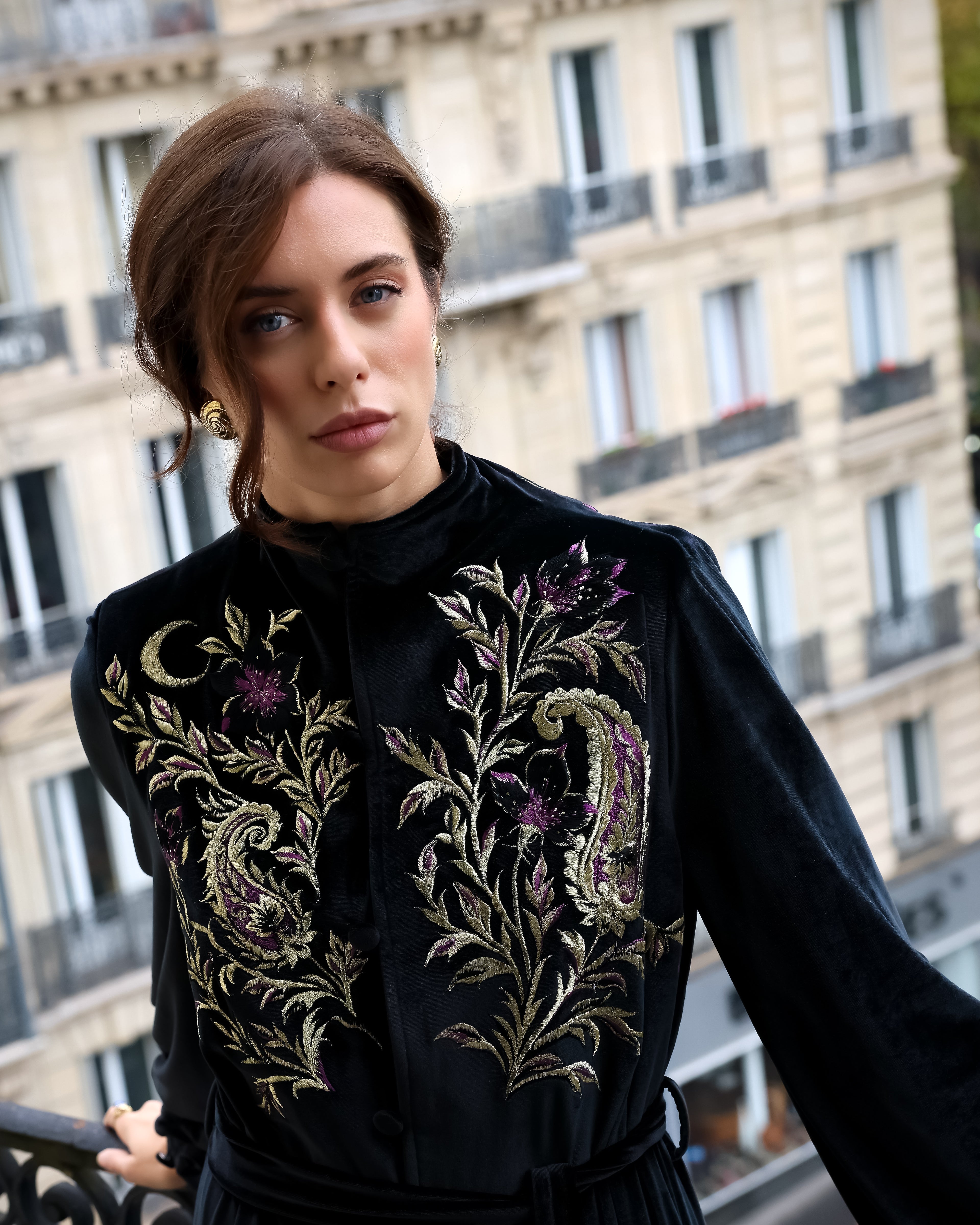 Woman wearing a black embroidered abaya in Paris. The Kimono abaya is handmade embroidered with silk threads. 