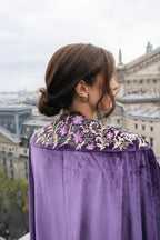 Person wearing a purple garment with floral hand embroidery in an urban setting.  Parisian style. Eid outfit. Ramadan outfit. Christmas party outfit. NYE outfit. Party look. Opera outfit. Gala outfit. 